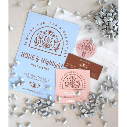 Overhead view of MINI Hone and Highlight Tumbling Medium by Rosy Revolver showing gray media pieces and branded packaging