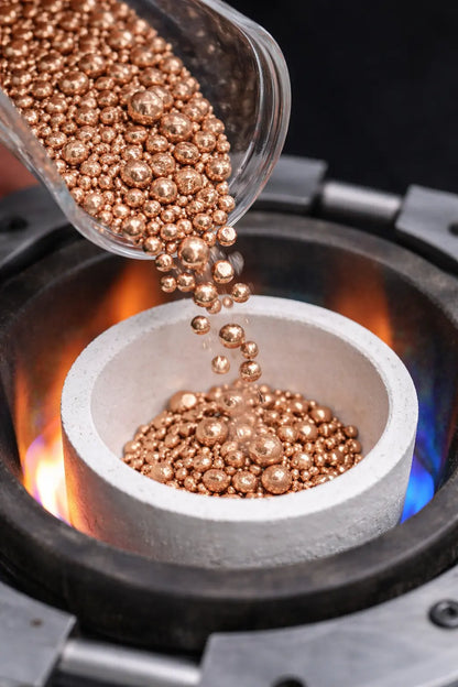 copper grain being melted in crucible for metal refining process