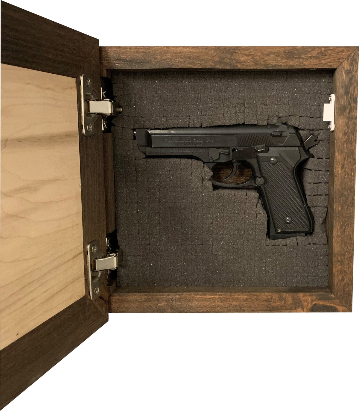 Open dark wooden wall safe with a black handgun nestled in cut-out foam inside.