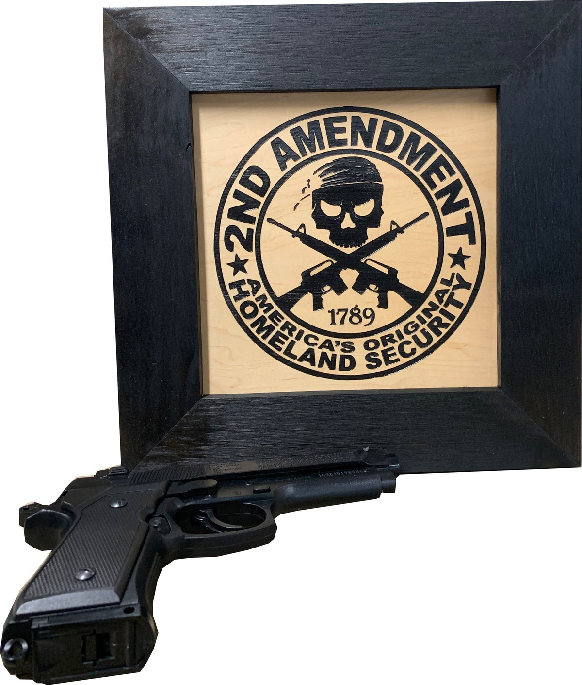 A framed wooden art piece featuring a skull, crossed rifles, and the text "2nd Amendment, America's Homeland Security".