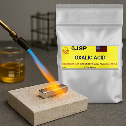 Front view of an oxalic acid powder bag with JSP Oxalic Acid label beside a torch-heated metal bar on a firebrick