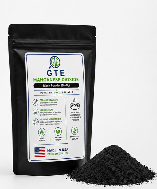 A black stand-up pouch of GTE Manganese Dioxide Black Powder (MnO2) with a white label, shown next to a small pile of the dark powder on a light gray background.