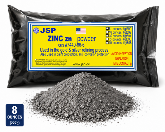 A black plastic bag of JSP zinc powder with a yellow label, shown with a pile of grey powder in front.