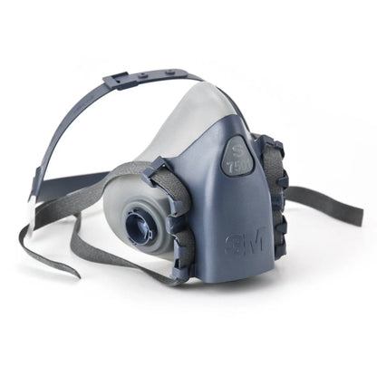 Angled view of 3M 7500 Series half face reusable respirator showcasing blue facepiece and adjustable straps on white backdrop