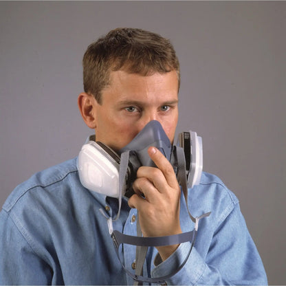 Front view of blue 3M 7500 Series Half Face Reusable Respirator worn by a person, showing side cartridges and straps