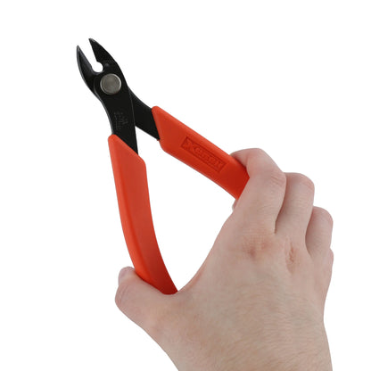 Angled view of Xuron Maxi-Shear Flush 2175 wire cutters showcasing red handles and flush-cut jaws with a hand on white