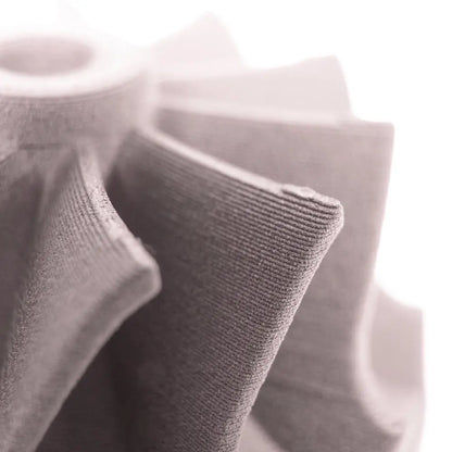 Close up of an Aluminum 6061 Filamet impeller showing layered 3D printed texture against a light background