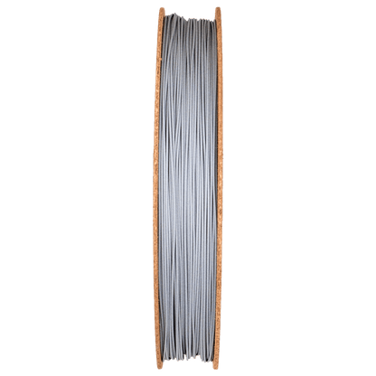 Front view of Aluminum 6061 Filamet showcasing gray filament wound on a wooden spool with a green background