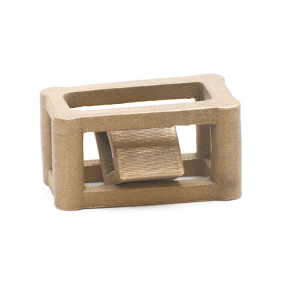 A matte bronze calibration block with a rectangular frame and a central diagonal element.