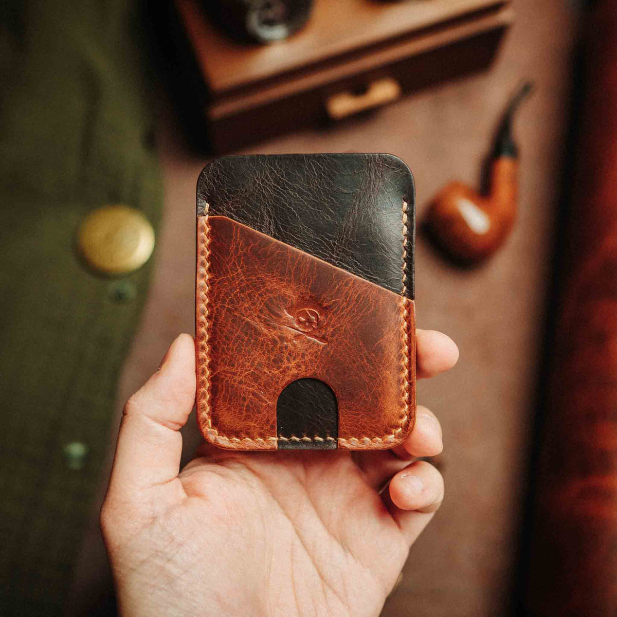 Front view of Pirate Goods Boatswain v4 slim wallet showcasing brown and black leather card pockets against a blurred desk background