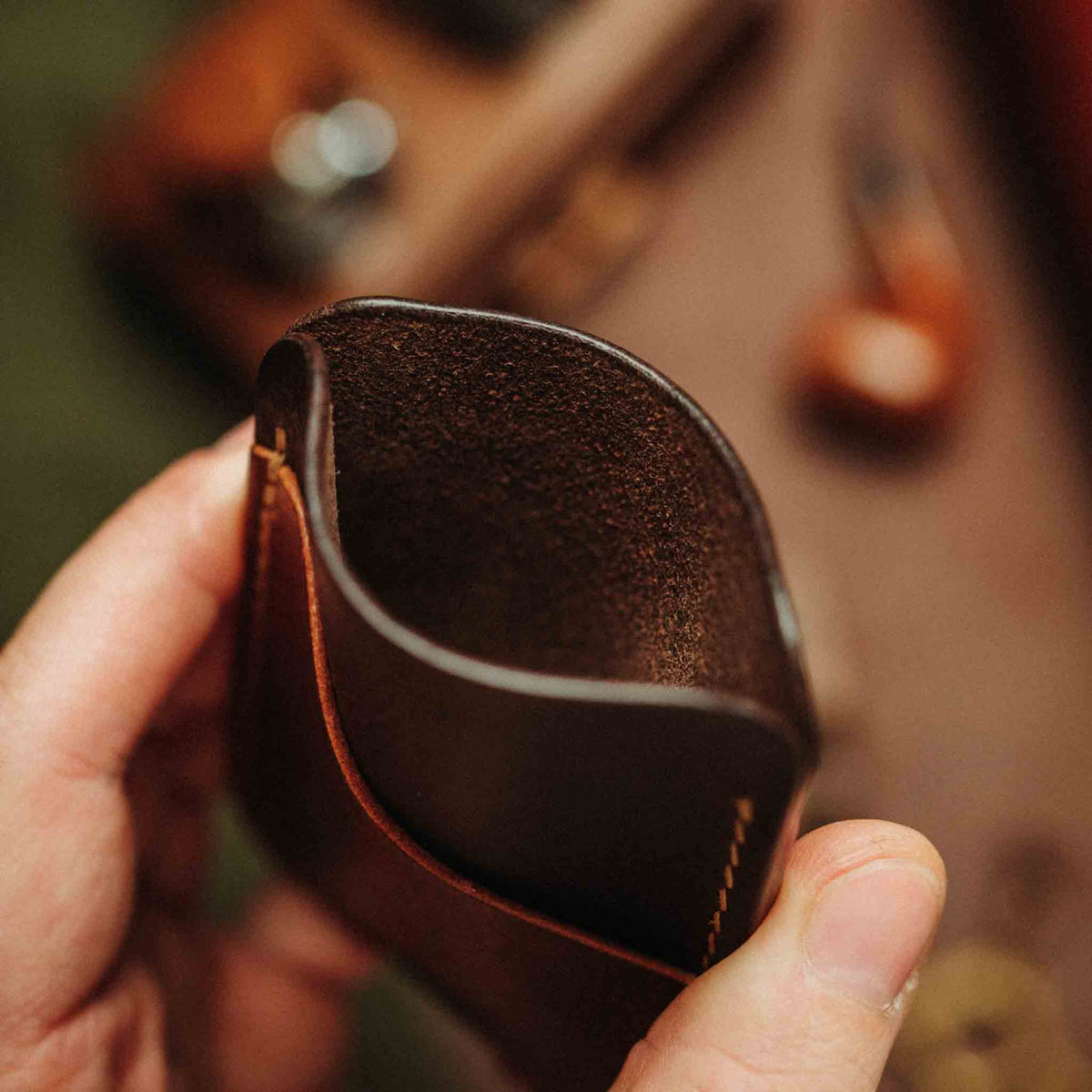 Close-up view of Boatswain v4 slim leather card holder showcasing textured leather and stitching in hand