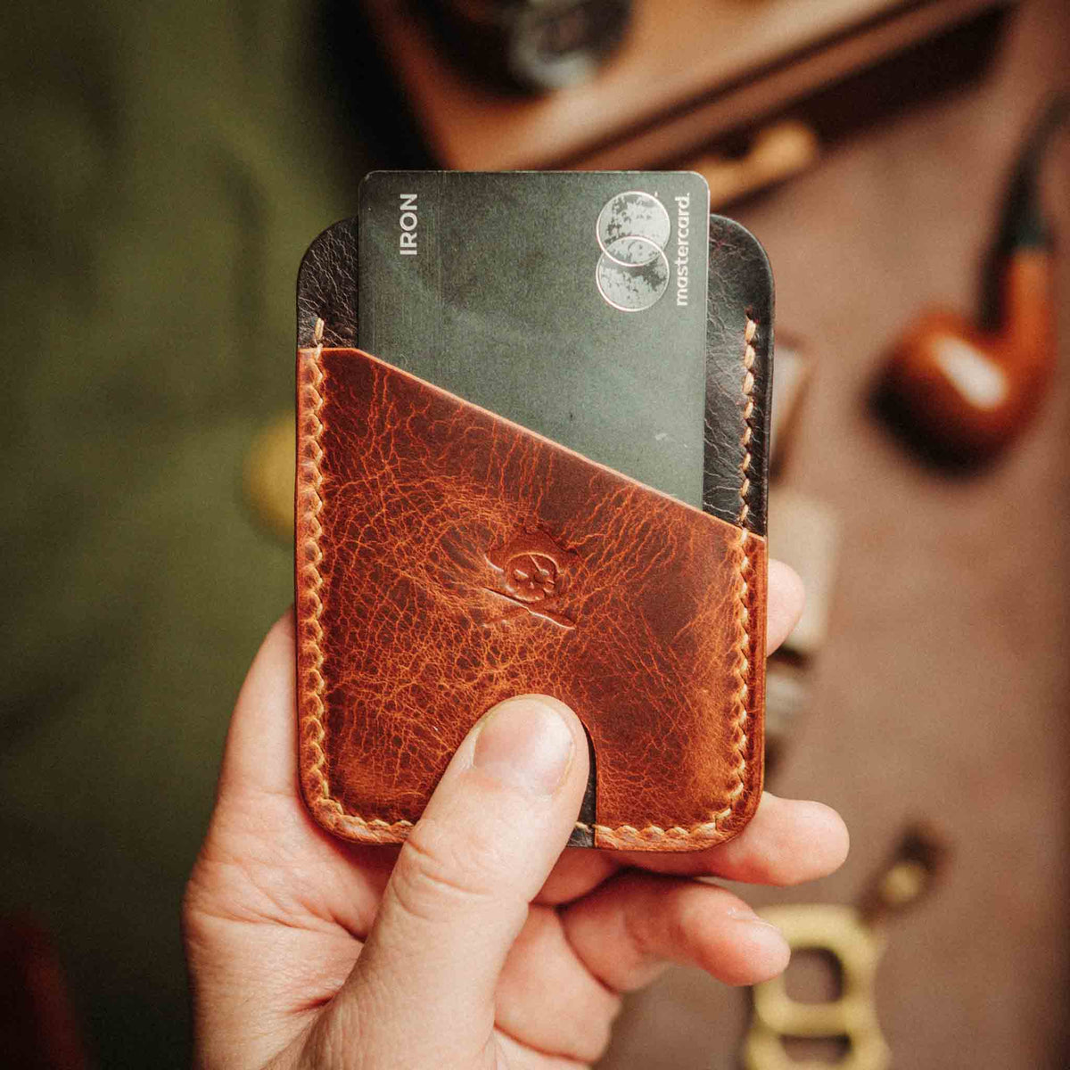 Front view of Boatswain v4 slim wallet showcasing textured leather and card slot, held in hand