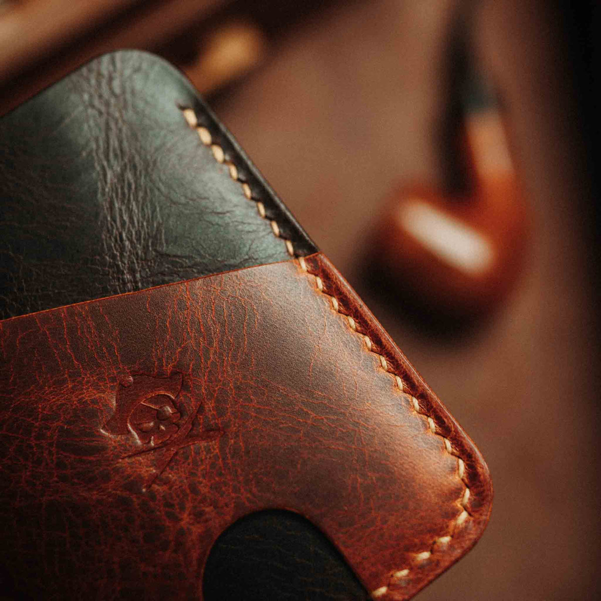 Close-up of Boatswain v4 slim wallet showing two-tone leather and stitched edges against blurred brown background