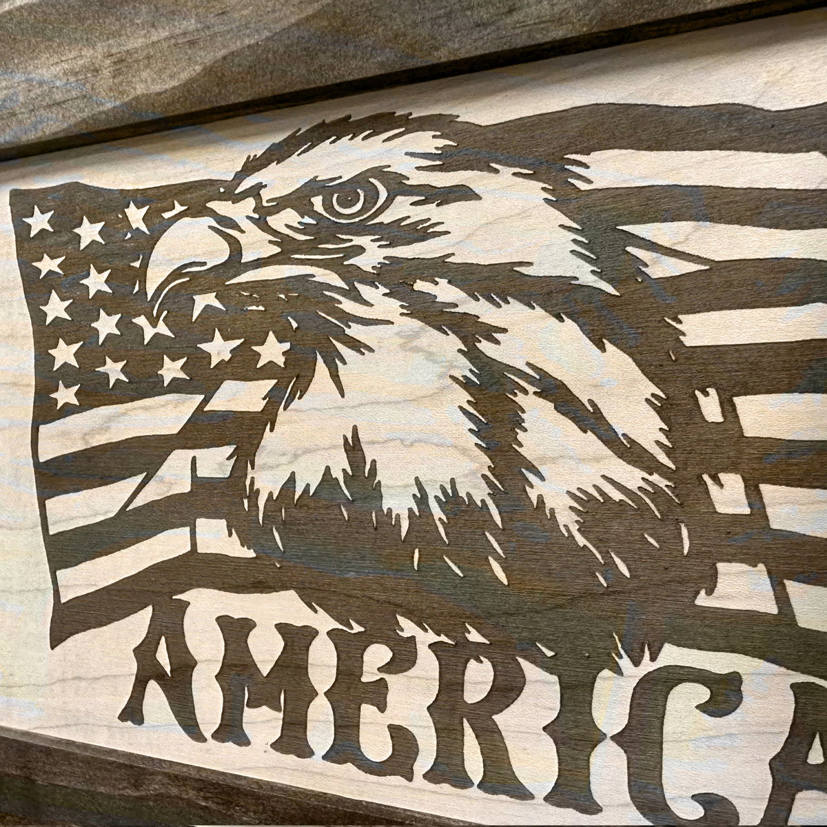 Laser-etched wooden sign of an American eagle profile against the U.S. flag, with "AMERICA" text below.