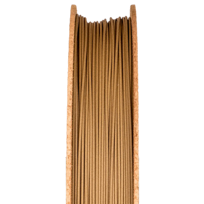 Front view of Bronze Filamet spool showcasing tightly wound bronze-colored filament against a black background