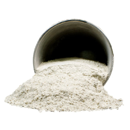 Magnesium silicate powder spilling from a metal scoop on a white background