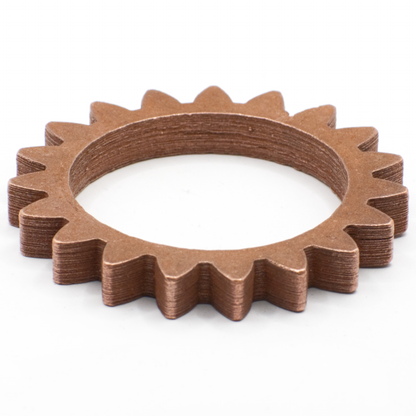 Angled view of a sintered copper spur gear showcasing its toothed ring design on a white background