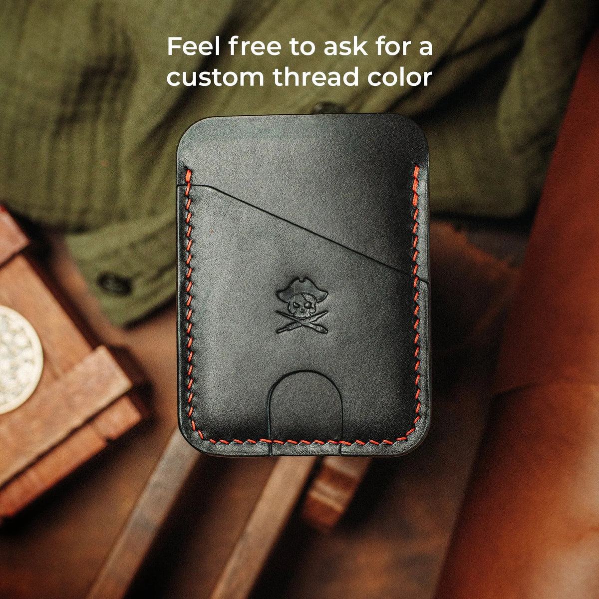 Front view of Boatswain v4 Slim Wallet with orange stitching on a wood background, captioned Feel free to ask for a custom thread color