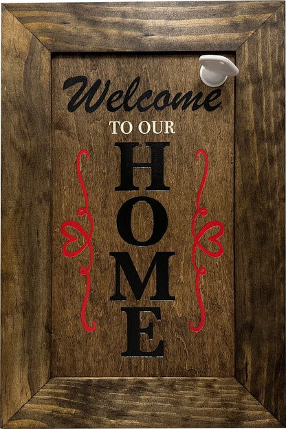 Front view of wooden secure gun safe wall decor with Welcome to our Home lettering, red scrollwork, and white lock knob