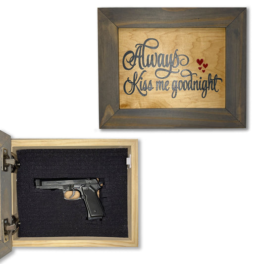A dark wood frame with "Always kiss me goodnight" text, opening to reveal a black handgun inside.