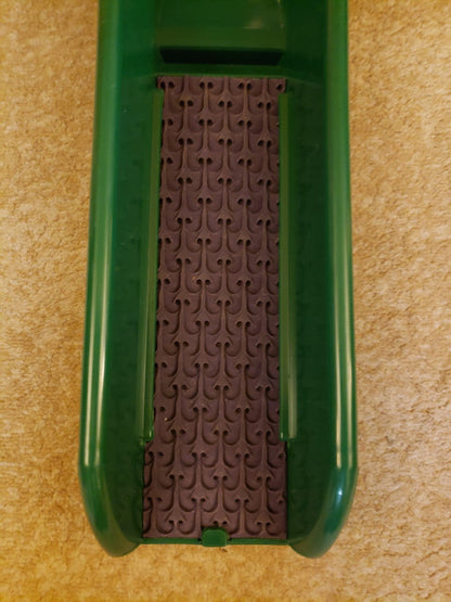 Top view of Micro Dream Mat 2nd Gen for Buddy showcasing a brown patterned insert in a green tray on beige carpet