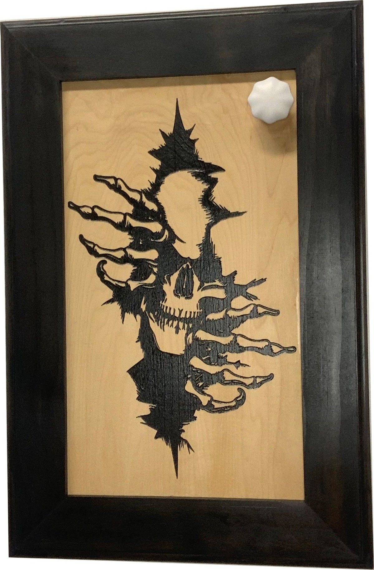 Framed wooden testing board with a black skull and skeletal hands laser-etched design.