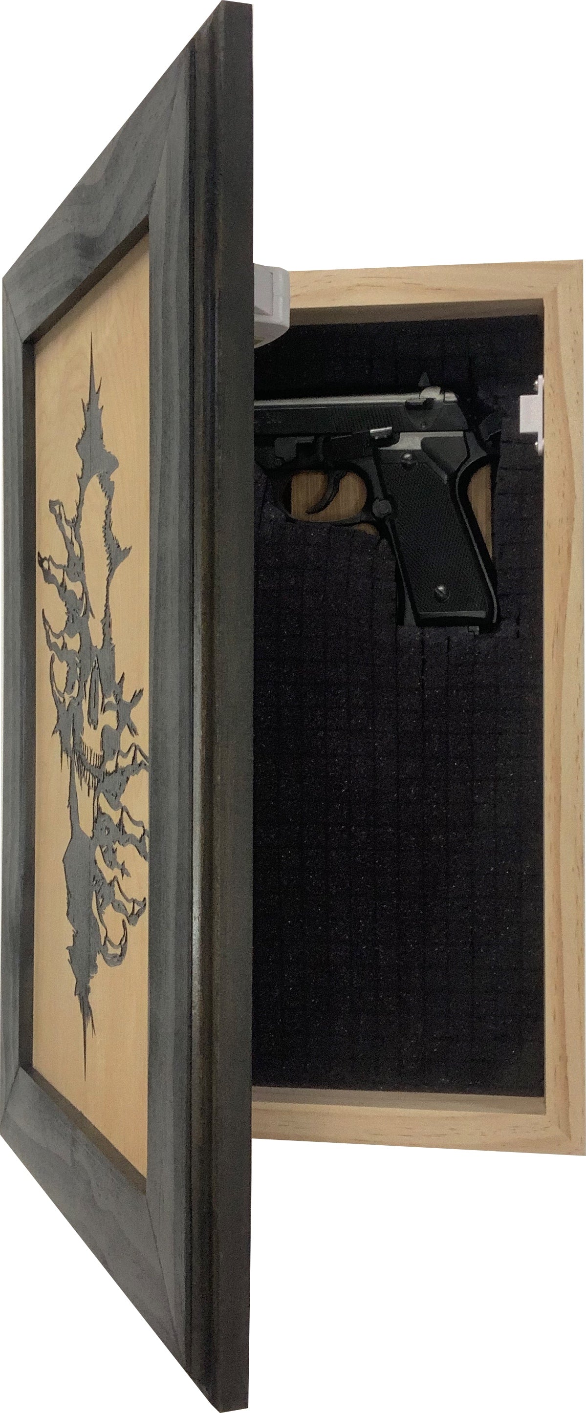 Open rectangular wooden hidden gun cabinet with a carved skull on the dark gray frame and a handgun inside.
