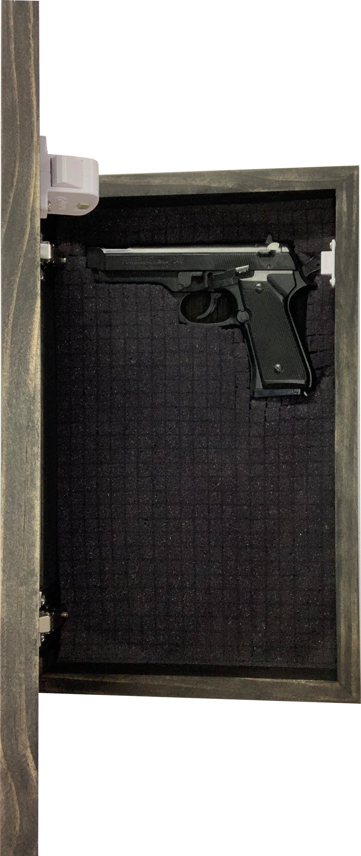 Dark brown wooden wall-mounted concealment box with a black foam interior, holding a handgun.