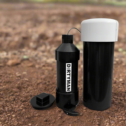 Black plastic "DIRTYMAN" gold prospecting testing equipment set with a white-lapped cylinder on a dirt ground.