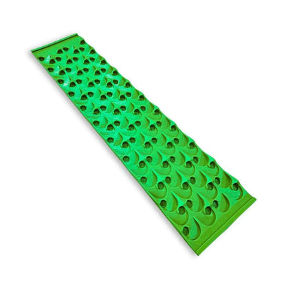 Angled view of 8X36 dredge sluice mat showcasing green raised riffles and circular openings on white background