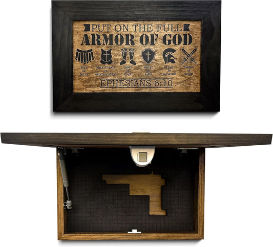 Rectangular wooden concealment wall art with black frame, showing "Armor of God" graphics, opening to reveal gun storage.