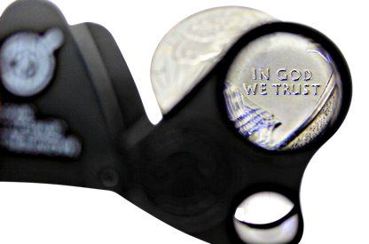 Close-up of a 30x 60x LED eye loupe magnifier showcasing a magnified coin with a transparent background