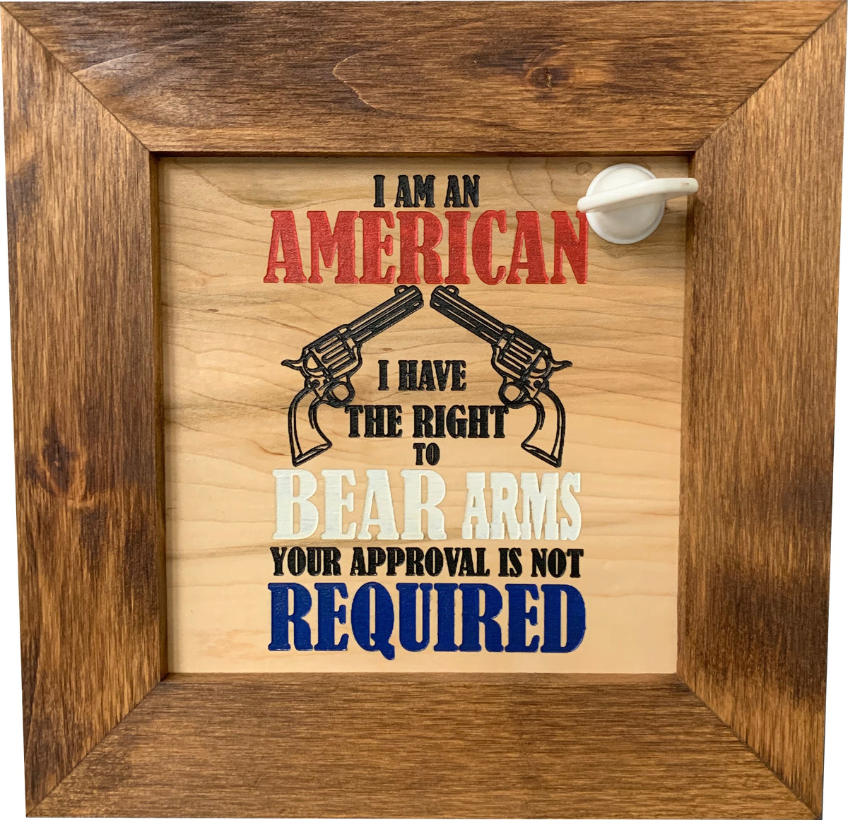 Wooden sign in a brown frame with text and two revolvers; reads "I am an American I have the right to bear arms..."