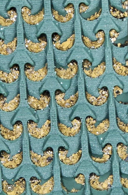 Close-up of Micro Dream Mat (2nd Gen) for Buddy showcasing gold flakes caught in textured channels with a teal background