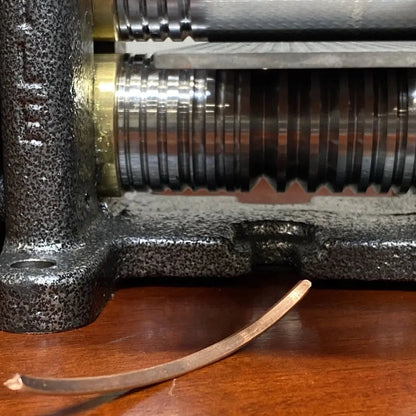 Close-up of Pepetools Triangle Mill with metal rollers shaping a copper strip