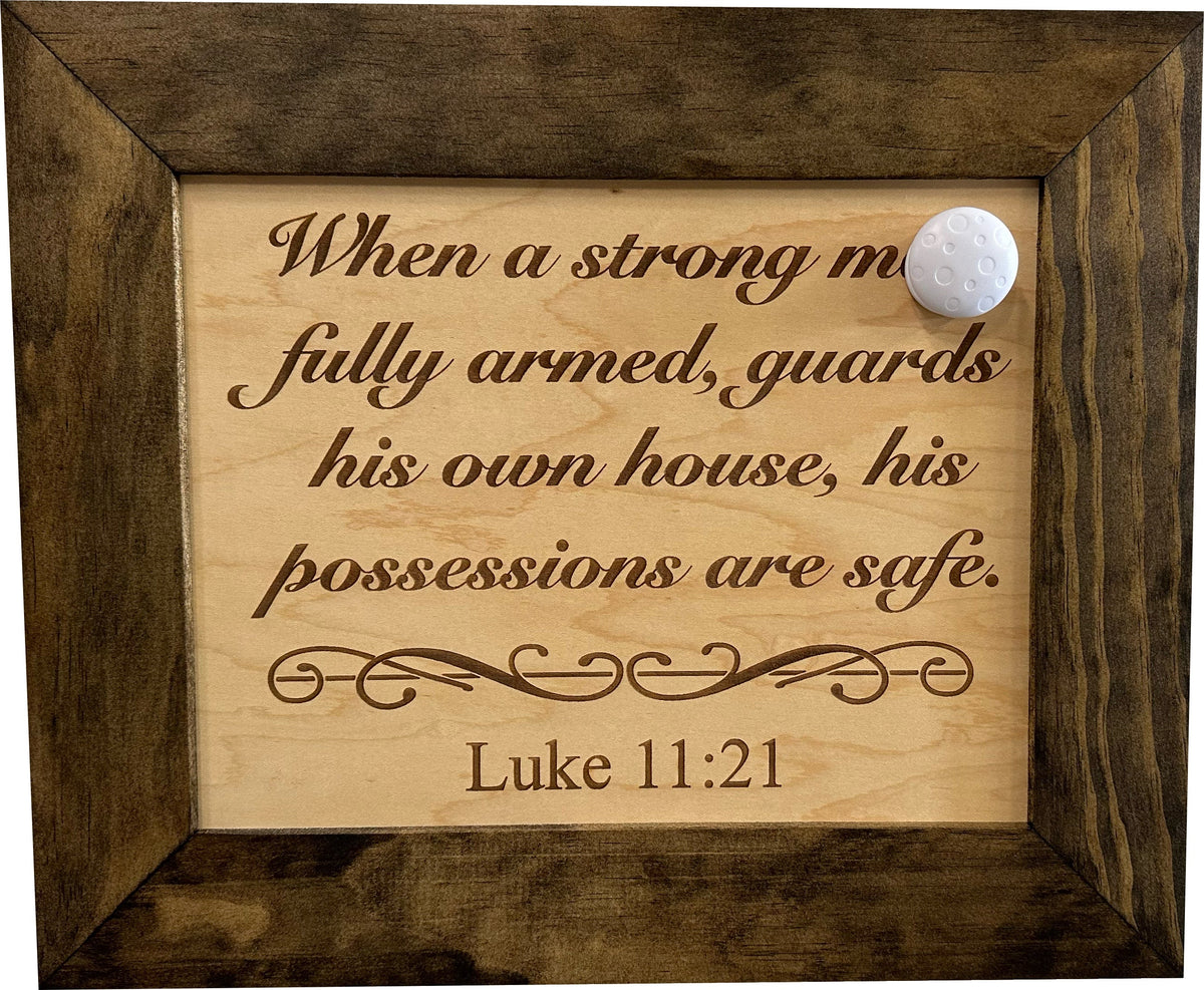 Wood-framed sign with engraved Luke 11:21 verse and a magnetic closure.