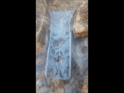 Top view of a mini pocket sluice box with Dream Mat in flowing water among rocks