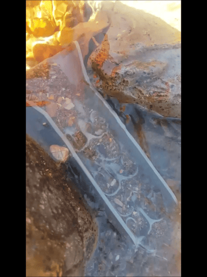 Angled view of mini pocket sluice box with Dream Mat containing gravel in flowing water