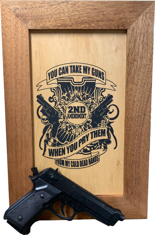 Framed wooden artwork reading "2ND AMENDMENT" and "YOU CAN TAKE MY GUNS..." with a black handgun in front.
