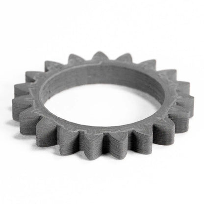 Angled view of Titanium 64-23 Filamet showcasing a gray 3D printed ring gear on a white background