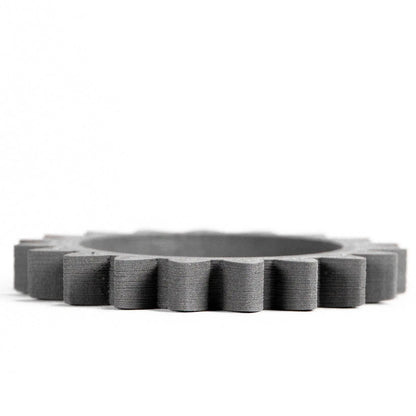 Front view of Titanium 64-23 Filamet showing a dark gray circular ring with layered ridges on a white background