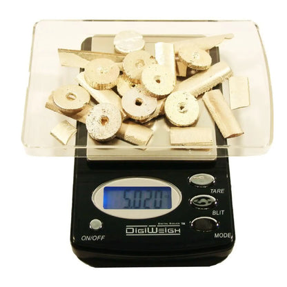 Front view of digital scale weighing metal pieces from complete gold, silver and platinum testing kit