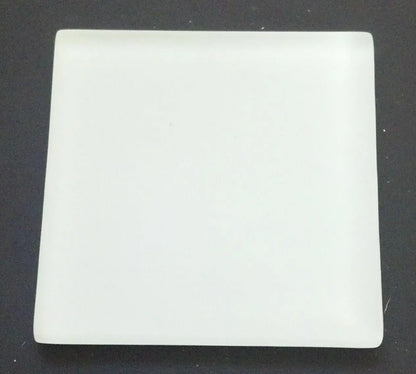 Top view of white 2 by 2 inch gold and silver testing touchstone showing a blank streak surface on dark background