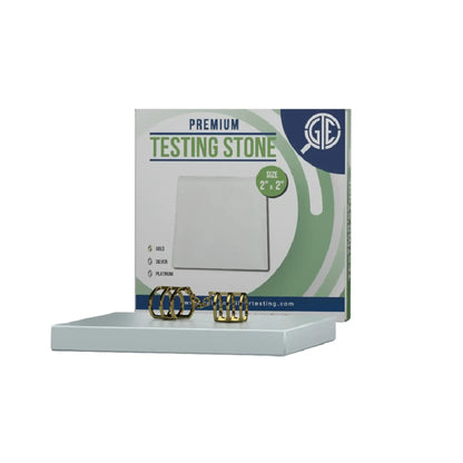 Front view of a white 2 by 2 inch testing touchstone with jewelry and product packaging on a white background