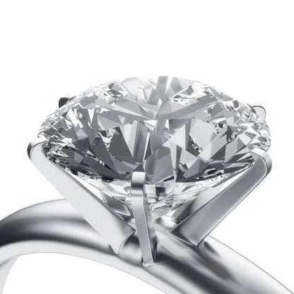Close-up of a silver-tone ring showcasing a large faceted clear gemstone on a white background